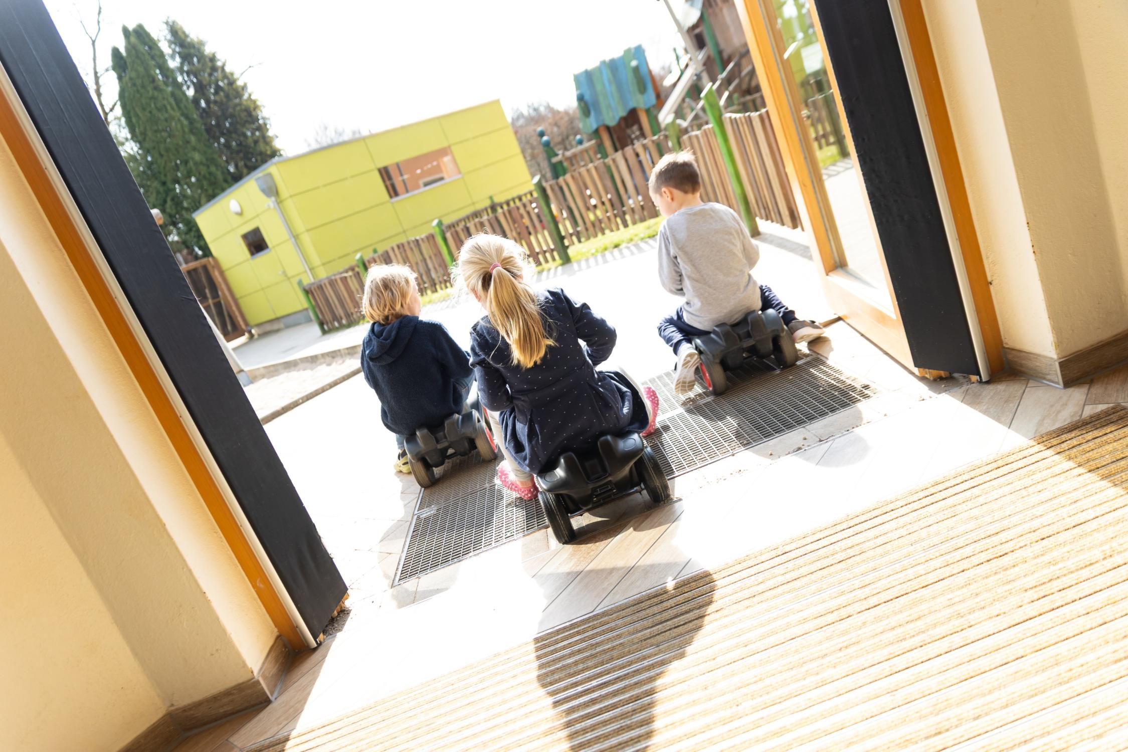 drei Kinder auf drei Bobbycars